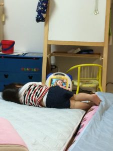 寝ながらDVDメイトを観る男の子の幼児