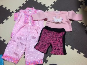 女の子の幼児用の服上下２枚が床に置いてあります